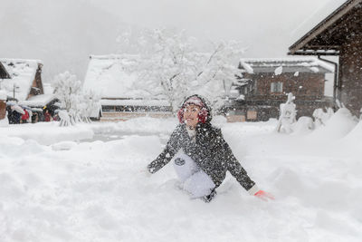 Woman with umbrella on snow covered building