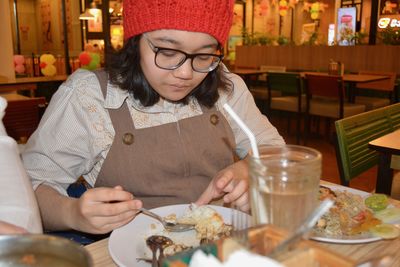 Midsection of woman holding ice cream in restaurant