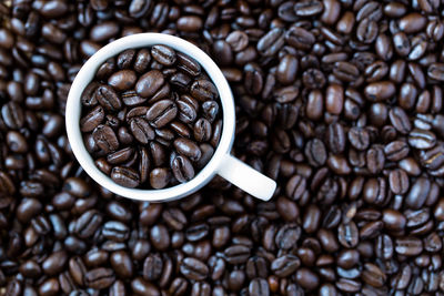 Close-up of roasted coffee beans with cup