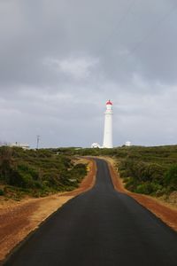 Road leading towards lighthouse against sky