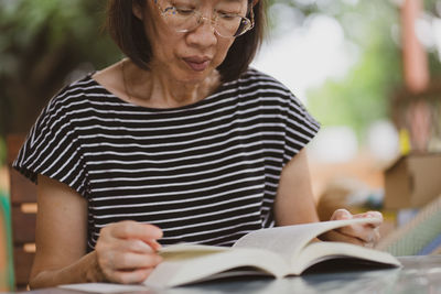 Midsection of woman reading book