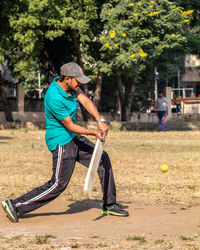 Man playing with umbrella against trees