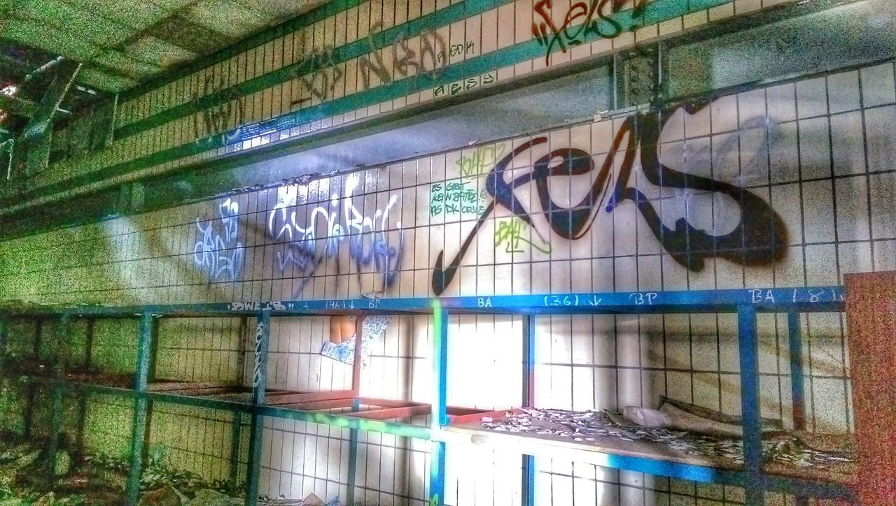 graffiti, built structure, architecture, building exterior, wall - building feature, art, art and craft, creativity, window, glass - material, building, wall, multi colored, indoors, reflection, blue, pattern, day, no people