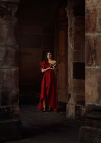 Woman standing against red brick wall