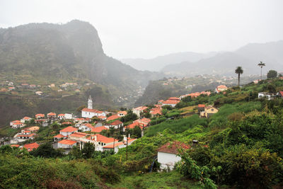 High angle view of townscape by mountain against sky