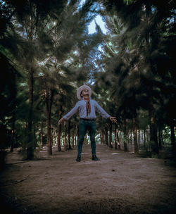 Portrait of young woman standing in forest