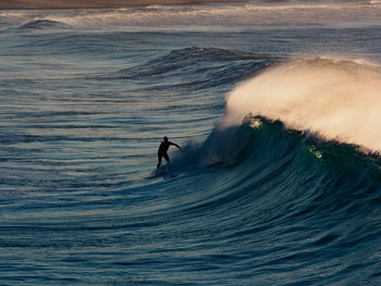 Silhouette man surfing in sea