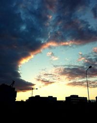 Silhouette of building against cloudy sky