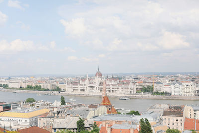 Buildings in city against cloudy sky