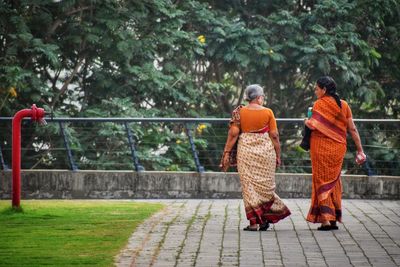 Rear view of women walking on tree