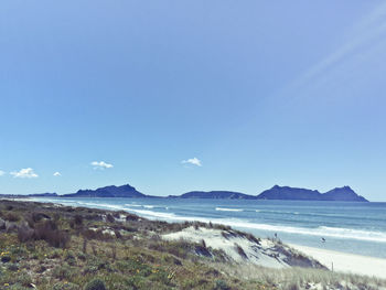 View of calm beach against blue sky