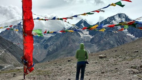 Rear view of man hanging on snowcapped mountain