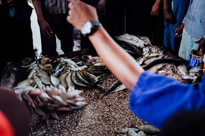 People holding fish at market