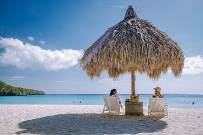 People on beach by sea against sky