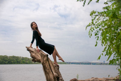 Young woman looking at sea against sky