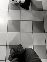 Low section of man standing on tiled floor