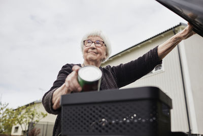 Woman putting rubbish into bin