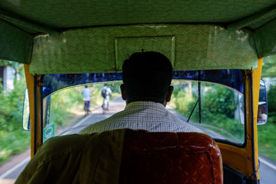 Rear view of driver driving jinrikisha on road