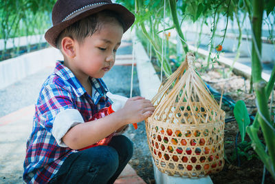 Boy looking away while sitting outdoors