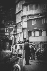 Rear view of people walking on street in city