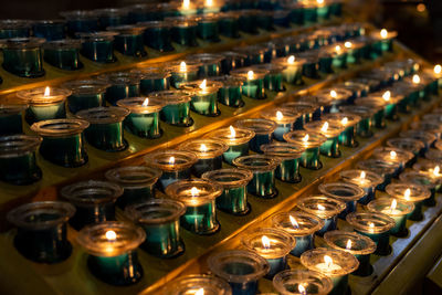 Row of illuminated candles in temple