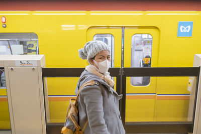 Full length of woman standing on train at subway station