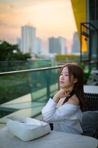 Portrait of young woman sitting on bed at home