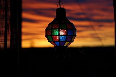 Close-up of illuminated lamp against sky during sunset