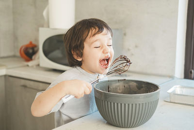 A little boy is cooking in the kitchen.