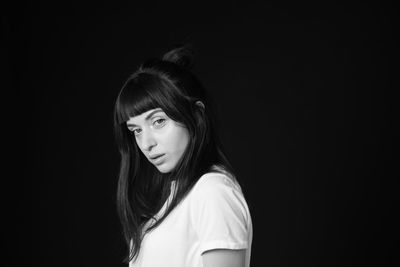 Portrait of a beautiful young woman over black background