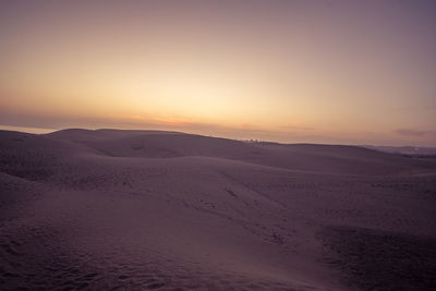 Scenic view of desert against sky during sunset