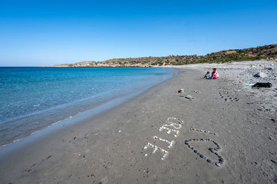 Scenic view of beach against clear blue sky