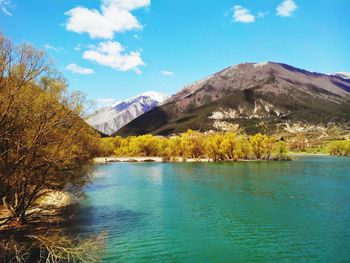 Scenic view of lake and mountains against blue sky