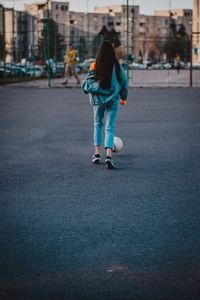 Rear view of woman walking on road