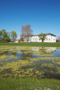 Scenic view of lake by building against clear sky