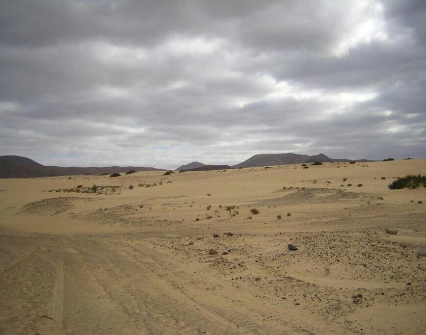 sky, tranquil scene, landscape, tranquility, cloud - sky, desert, cloudy, sand, scenics, arid climate, beauty in nature, nature, cloud, barren, remote, sand dune, non-urban scene, mountain, physical geography, horizon over land