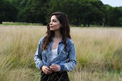 Portrait of beautiful woman standing on field