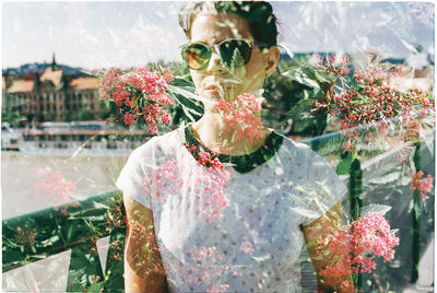 Double exposure of flowering plants and woman wearing sunglasses