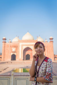 Woman looking away while standing against taj mahal