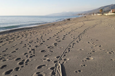 Footprints on beach against sky