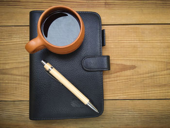 High angle view of black and pencils on table