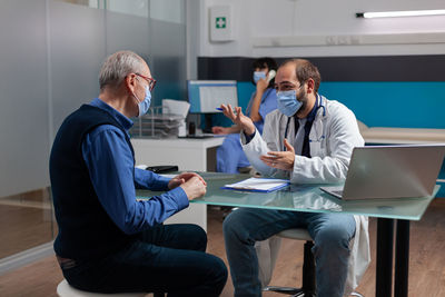 Male doctor discussing with patient at clinic