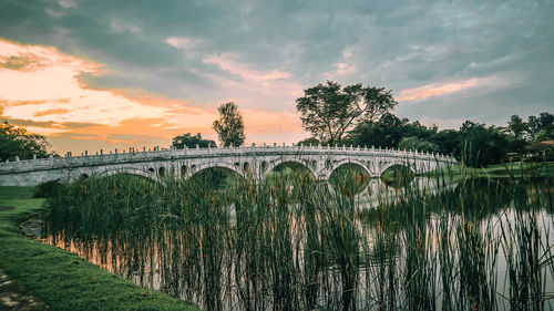 Bridge over river against sky during sunrise