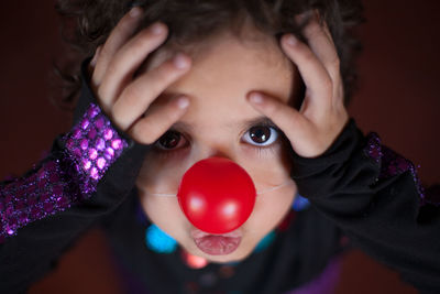 Close-up portrait of a girl wearing clown nose