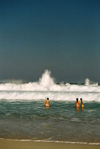 People enjoying in sea against sky