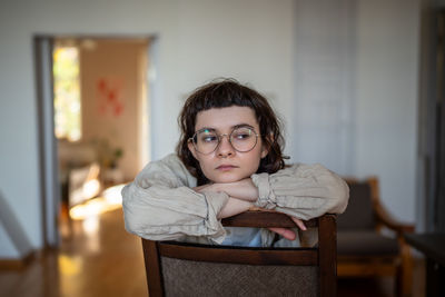 Portrait of young woman sitting at home