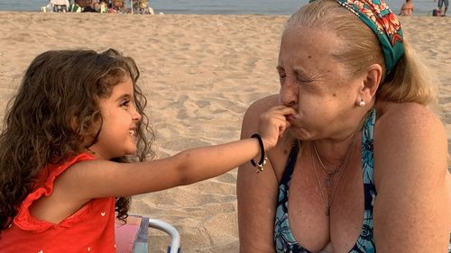 Cute granddaughter playing with grandmother