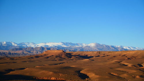 Scenic view of snowcapped mountains against clear blue sky