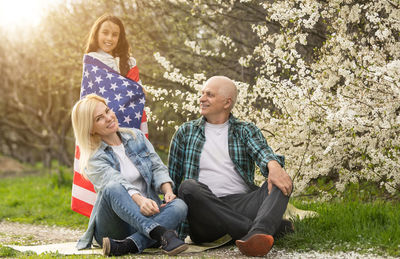 Portrait of happy family celebrating 4th july independence day holding silhouette usa national flag 