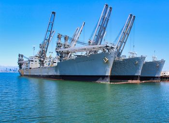 Commercial dock by sea against clear blue sky